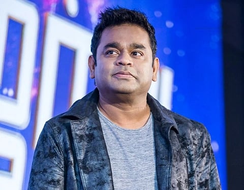 Image of Two-time Academy Award recipient AR Rahman At The ‘Marvel Anthem’ Launch. he is wearing a jacket and behind him a huge led frame is placed which is blurred.