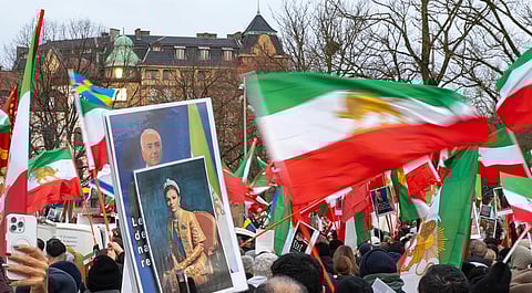 A vibrant protest scene with people holding numerous Iranian flags amid large crowd. Framed portraits of a man and a woman are visible.
Iranian dissidents attend an anti-Iranian regime protest in Gothenburg, Sweden at Bältespännarparken in Gothenburg, Sweden on January 17, 2026. Some wave the Lion and Sun flag and hold placards showing Reza Pahlavi.