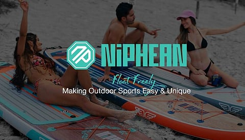 Three people in swimsuits sit on paddleboards on a sandy beach, smiling and relaxed. Text overlay: "NiPHEAN: Making Outdoor Sports Easy & Unique."