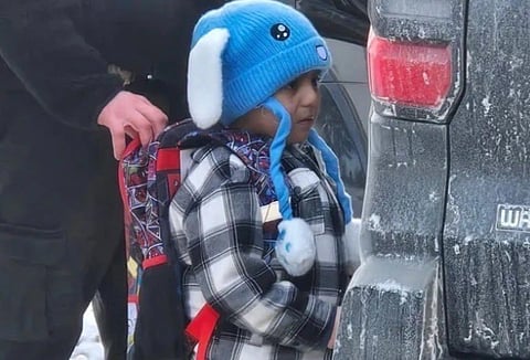 Image of five year old Liam Conejo Ramos detained by an ICE agent. His hand is over Liam's backback.