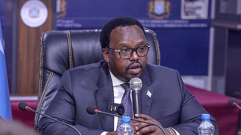 In the image Somalian DY Prime minister is addressing people, he is wearing the coat in a formal setting