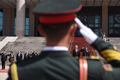 A Chinese military official salutes another from afar.