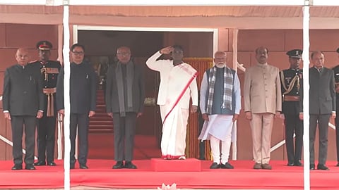 President Murmu saluting outside the parliament, while Modi, Radhakrishnan, Birla, and Rijiju stand beside her.