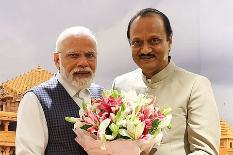 Image of PM Narendra Modi (left) and Ajit Pawar (right). they are holding a bouquet and posing for the camera.