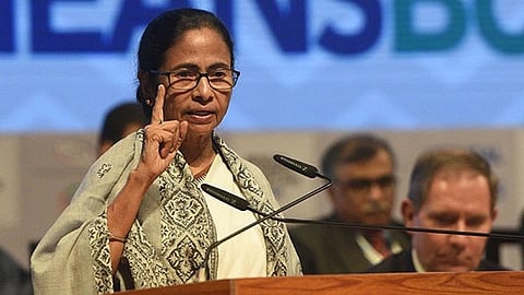 In the image Mamata Banerjee is shown addressing public through a podium