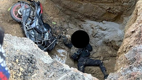The uncovered muddy pit- biker lying dead beside his bike, biker's face blacked out