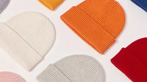 Colorful knitted beanies arranged on a white background. The hats are in colors like orange, red, and white, conveying a cozy, vibrant feel.