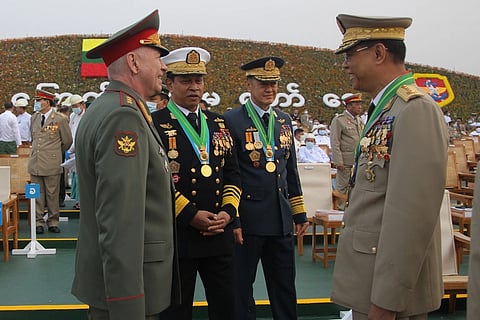 Colonel General Alexander Fomin, Admiral Tin Aung San, General Mya Tun Oo, and General Maung Maung stand facing each other during a parade in their formalwear with medals.