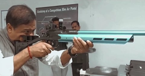 CM Himanta Biswa Sarma holding a rifle at a gun range, aiming for a shot