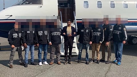 In the image Nikhill Gupta is shown with US police in a Aeroplane station