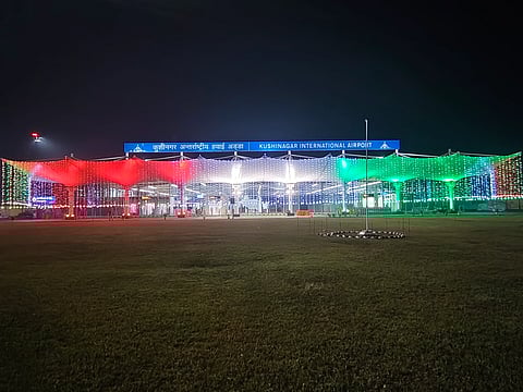 Kushinagar International Airport at night, adorned with festive red, white, and green lights, on the occasion of Republic Day 2026. A large, illuminated sign is visible above the entrance.