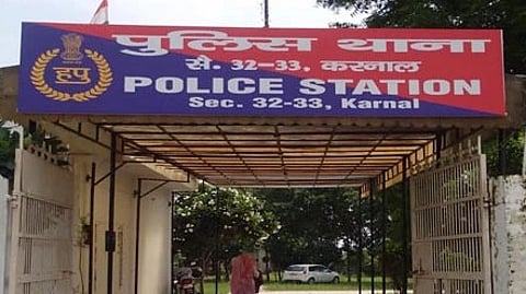 Front entrance of Sector 32-33 police station, Karnal, with a blue and red board above.
