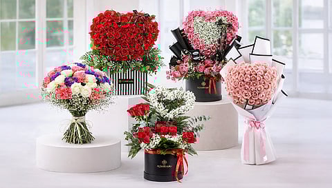Elegant floral arrangements displayed in light-filled room. Bouquets feature red, pink, and multicolored roses, some heart-shaped, exuding romance and beauty.