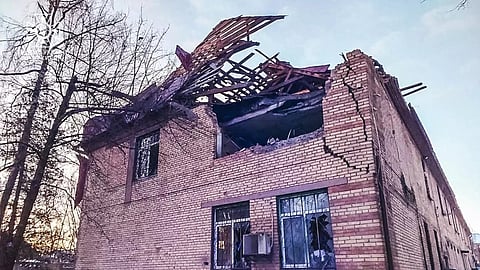 The image shows a damaged house, destroyed by Russian drone strikes in Ukraine.