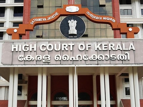 image of kerala high court building. at the top of the arch of the building satyameva jayathe is written in english and in malayalam