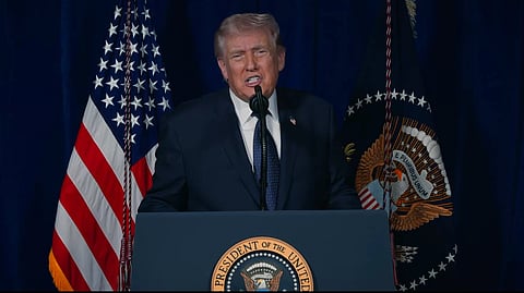 Trump, mid-speech, standing behind a podium at the White House