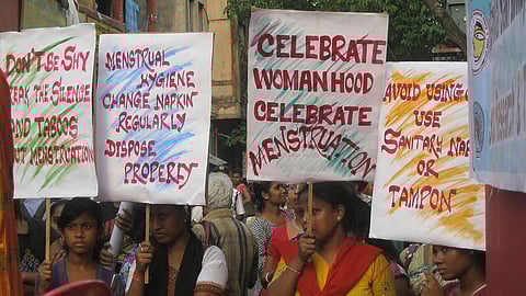 women holding up placards spreading menstrual awareness