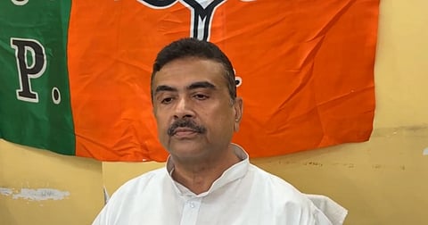 In the image Suvendu Adhikari is shown and behind him is BJP flag