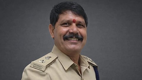 Mood Kishan in a police uniform with badges, featuring short dark hair and a mustache, against a neutral gray background, conveying a friendly demeanor.
