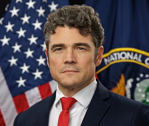 Official portrait of Joe Kent with American flag behind him.