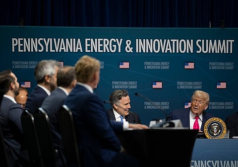 Donald Trump sits in front of a board readng 'Pennsylvania Energy and Innovation Summit' facing other panelists