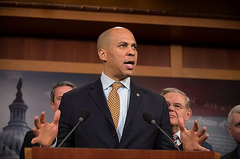Sen. Booker speaking at a press conference in the U.S. Capitol, emphasising with both hands in front of a podium