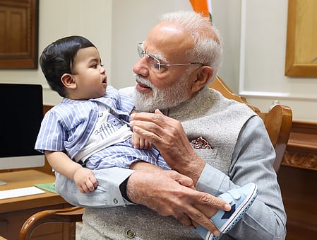 PM Modi cradles little Omy, melts hearts across social media