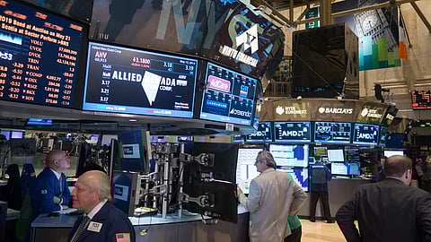 Men in suits and unifroms stand in front of many moniters with numbers and data