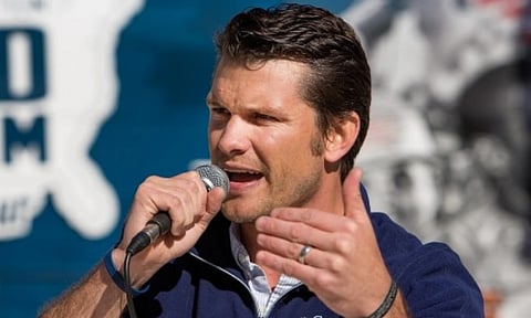 Image of Pete hegseth speaking at a event and holding a mic. in the image he is speaking at the Defend Freedom Tour in 2013