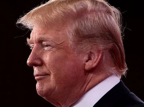 Image of Donald Trump looking sideways. the background is dark. the image is of President of the United States Donald Trump speaking at the 2018 Conservative Political Action Conference (CPAC) in National Harbor, Maryland.