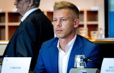 Image of Péter Magyar wearing a dark blue suit during AFCO Committee constitutive meeting. he is seated in front of a table with a board that has his name on it.