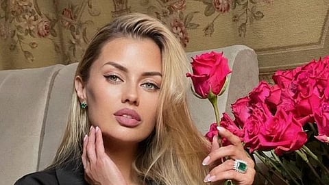 In the image Viktoria Bonya is shown with a rose in her hand she is posing for the camera