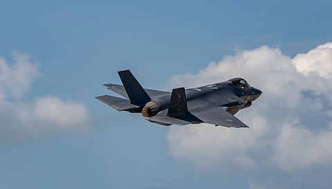 Operation Roaring Lion, 2026: Image of A sleek military jet soars through a clear blue sky, flanked by fluffy white clouds. The aircraft's powerful engines convey a sense of speed and precision.