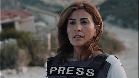 Amal Khalil stands in a Press vest