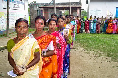 In the image a long line of voters is shown with their voter ID