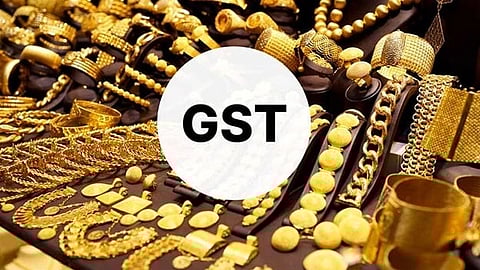 A variety of gold jewelry, including necklaces and bracelets, displayed with a white circle overlay containing the text "GST" in bold black letters.