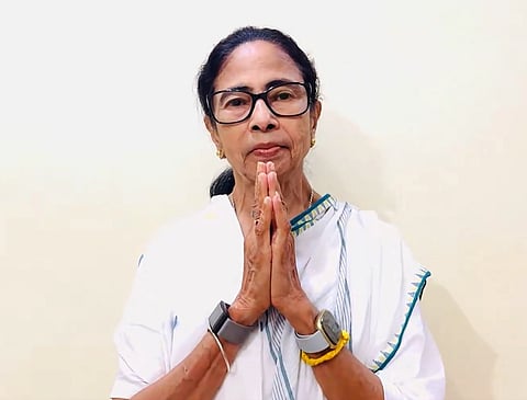 Image of mamata Banerjee talking to the camera. her hands are folded.