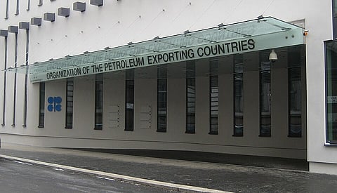 Modern building with a glass canopy labeled "Organization of the Petroleum Exporting Countries". OPEC logo is visible on the wall. Overcast weather.