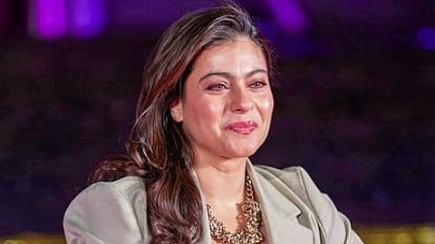 In the image kajol is seen smiling in a stage