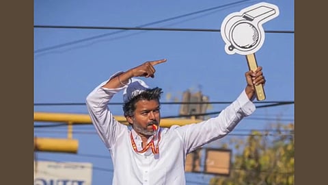 In the image Vijay is shown with a whistle and pointing towards a cardboard with a Whistle drawn in it