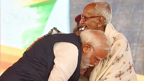 In the image PM Modi is shown hugging BJP Veteran leader Makhanlal Sarkar