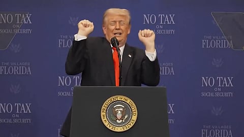 Trump with his hands up at a podium
