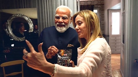 PM Modi with Meloni and Melody Toffee packet in their hands meloni is recording with her phone