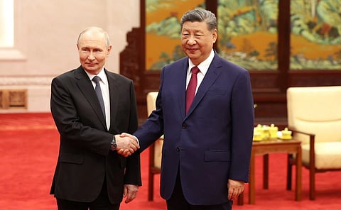 In the image Putin is shown with Xi Jinping shaking hands and posing for the camera