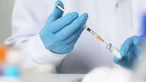 image of a gloved hand holding a syringe