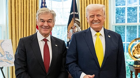 Two men in suits, Mehmet Oz and Donald Trump, standing side by side, smiling at the camera.