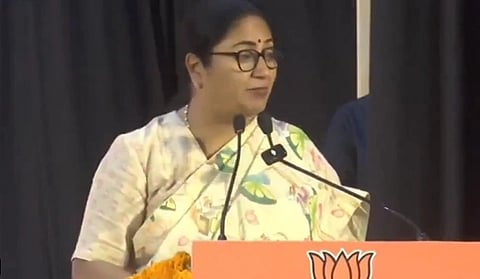 In the image Delhi CM Rekha Gupta is shown addressing the people in a BJP public event