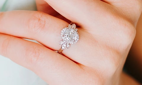 In the image a hand is shown with a beautiful ring in the ring finger