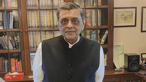 Bombay High Court Judge Gautam Patel in a vest stands before a bookcase filled with legal texts and books.