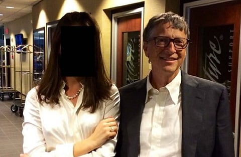 Image of Bill gates with a female whose face is redacted. They are both in a hallway with doors. The atmosphere is formal and friendly.